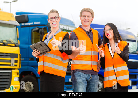 Logistique - fier conducteur ou le transitaire et collègues avec ordinateur tablette, en face de camions et remorques Banque D'Images