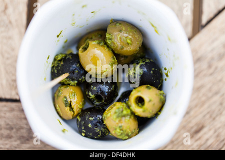 Délicieux à la recherche d'olives noires et vertes dans un petit bol avec une vinaigrette aux fines herbes et d'huile Banque D'Images