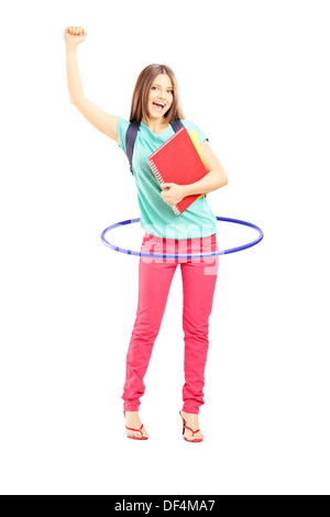 Portrait of a young female student holding notebooks et jouer avec un hula-hoop Banque D'Images