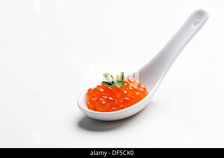 Caviar rouge en cuillère en céramique blanche Banque D'Images