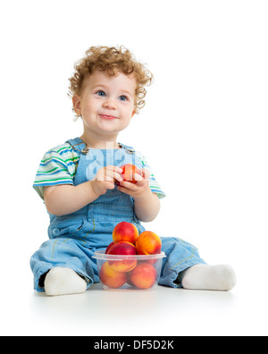 Bébé garçon manger des fruits isolé sur fond blanc Banque D'Images