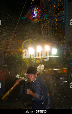 Les hommes indiens frapper une piñata pour célébrer avant de prendre l'idole de Ganesh pour l'immersion. Banque D'Images