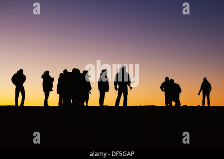 Silhouettes de personnes en face de Ciel de coucher du soleil. Pris sur le dessus de Haleakala sur Maui, Hawaii. Banque D'Images