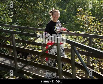 Ngleton UK. 28 Septembre, 2103. Les membres de Batala Samba Band traversant la passerelle en bois sur la route de Ingleton Falls Cascade pour leur événement de percussion. La musique de l'eau a pris une signification différente pour les membres de la bande 'percussions samba Batala Lancaster' le samedi. Ils ont joué leurs instruments tout en se tenant dans le cours d'eau ci-dessous Thornton Force - sur la chute d''Ingleton à pied. L'événement de bienfaisance était de faire un vrai splash pour la fondation d'éducation Longstaffe, Bentham. Banque D'Images