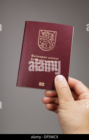 Homme tenant un finnois (Finlande) passeport ih sa main. C'est la nouvelle (2013) du passeport. Banque D'Images