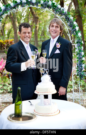 Beau gay couple toasting with champagne sur leur magnifique réception de mariage en plein air. Banque D'Images