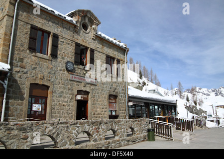 Un bâtiment de la gare construit en pierre dans le style français avec des montagnes enneigées. Banque D'Images