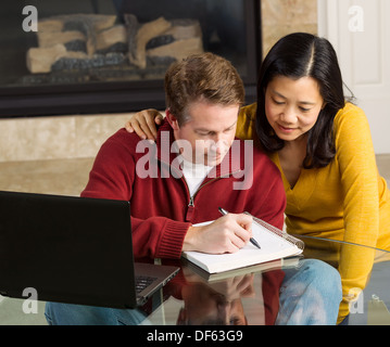 Photo de couple étroitement travailler ensemble à la maison avec cheminée en arrière-plan Banque D'Images