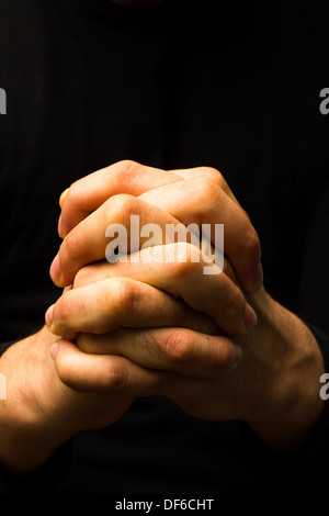 Les mains du jeune homme en prière plié Banque D'Images