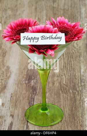 Joyeux anniversaire carte avec gerberas rose dans un verre à martini Banque D'Images