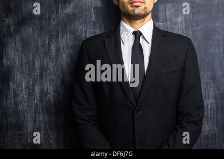 Young businessman standing in front of blackboard Banque D'Images