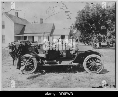 Photographie d'une voiture ouverte garée dans la cour d'une maison à Omaha, reflétant un style de vie typique de banlieue américaine du milieu du XXe siècle. Banque D'Images