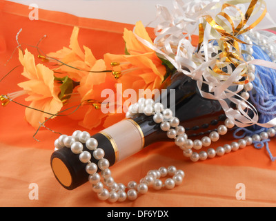 Fleurs, diamants blancs et une bouteille de champagne Banque D'Images