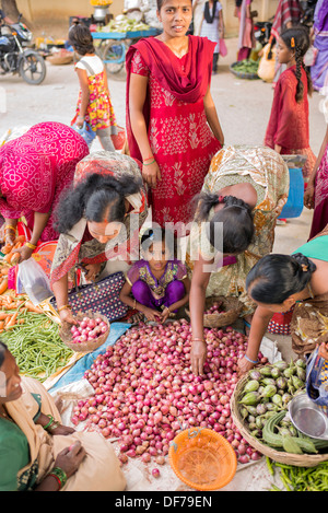 Indian girl chez les mères l'achat de légumes d'un marché de rue. Puttaparthi, Andhra Pradesh, Inde Banque D'Images