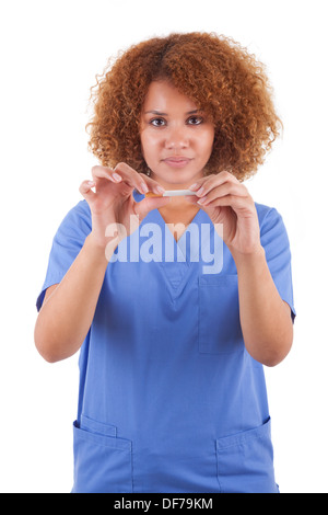 African American nurse holding a broken cigarette, isolé sur fond blanc - les noirs Banque D'Images