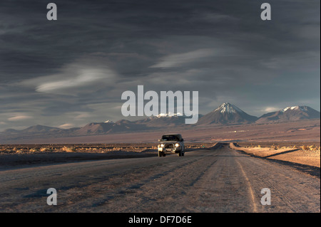 Voiture sur une route de terre, au crépuscule, en région d'Antofagasta, Chili Banque D'Images