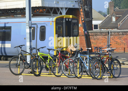 Cycles les navetteurs à gauche des supports à vélos sur la plate-forme de la gare (train détails & branding retiré numériquement) Banque D'Images