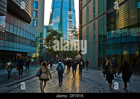 Les gens qui marchent à travers plus London Place au coucher du soleil Banque D'Images