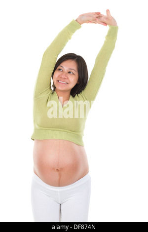 La notion de santé de la maternité. Femme enceinte asiatique s'étendant les bras isolé sur fond blanc. Banque D'Images