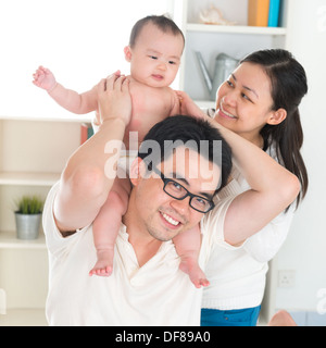 Portrait of Asian parents et six mois bébé fille jouer à la maison. Banque D'Images