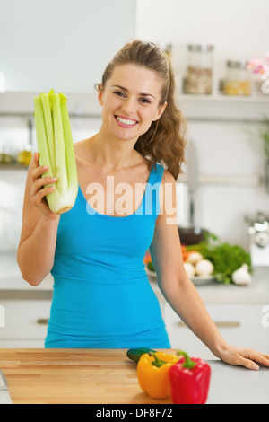 Jeune femme le céleri dans une cuisine moderne Banque D'Images