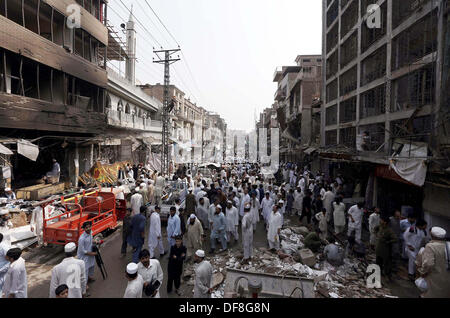 Les gens et les fonctionnaires occupés sauve dans un sauvetage sur le site de l'explosion d'une bombe hier au poste de police de Raziq Khan Qissa Khawani Zone Bazar de Peshawar le lundi, 29 septembre 2013. Au moins 37 personnes ont été tuées et plus de 80 blessés dans une explosion près de Khan Raziq de police de Qissa Khawani bazar de Peshawar. Plusieurs véhicules et bâtiments adjacents ont été endommagés. Les forces de l'ordre ont encerclé la zone. Banque D'Images