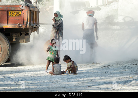 Les enfants indiens jouant, entouré par la poussière, sans protection, à l'écrasement fonctionne. L'Andhra Pradesh, Inde Banque D'Images