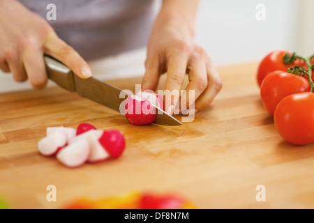 Gros plan sur les radis coupe femme on cutting board Banque D'Images