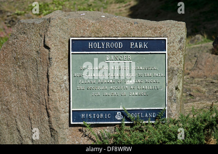 Un signe à Holyrood Park avertissent des dangers de l'escalade à proximité sur Salisbury Crags. Banque D'Images