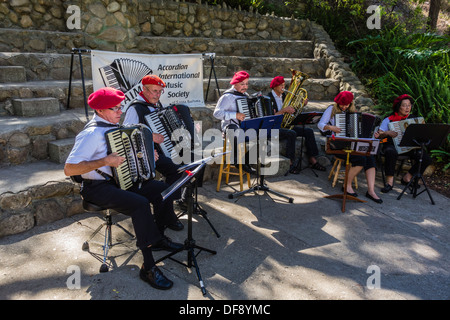 La Société Musicale Internationale Accordéon jouer dehors et portant des bérets rouges à Santa Barbara, en Californie. Banque D'Images