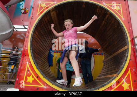 Petite fille dans l'équilibrage du tube rotatif, grande foire de l'État de New York Banque D'Images