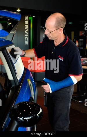 Mini car dans un showroom être enveloppé avec des logos pour un client à des fins de promotion Banque D'Images