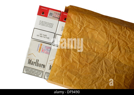 Cartouches de cigarettes de contrebande sur le marché noir dans un sac de papier brun froissé Banque D'Images