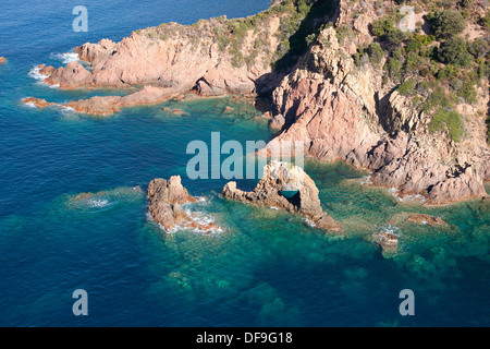 VUE AÉRIENNE.Côte accidentée de roche rouge volcanique avec une arche naturelle dans le golfe de Porto.Partinello.Corse, France. Banque D'Images