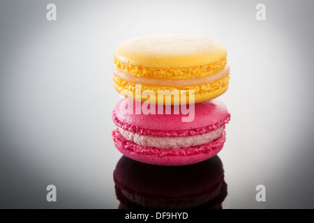 Macarons colorés empilés sur un gradient background Banque D'Images