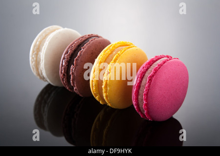 Délicieux macarons de différentes saveurs et couleurs sur gradient background Banque D'Images