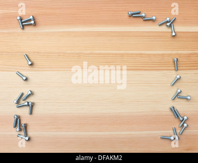 Vis à tête forme une frontière recto-verso sur fond de bois Banque D'Images