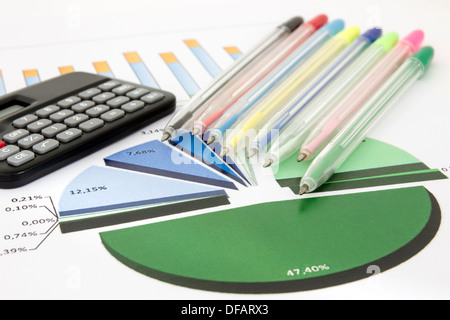 Tableau d'affaires avec une calculatrice et un tas de stylos de couleur Banque D'Images