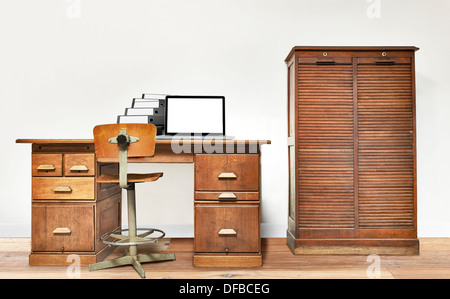 Ordinateur portable et étendu sur un dossier vintage 24 dans une chambre avec plancher en bois Banque D'Images