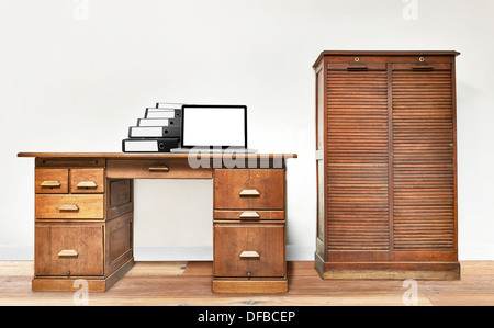 Ordinateur portable et étendu sur un dossier vintage 24 dans une chambre avec plancher en bois Banque D'Images
