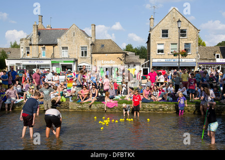 UK,Bourton-on-the-Water:personnes jouent dans la rivière Windrush. Bourton est une destination touristique populaire dans la région des Cotswolds. Banque D'Images