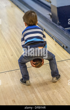 Trois ans de parution modèle garçon, bénéficiant d'une partie de bowling, une activité amusante. Banque D'Images