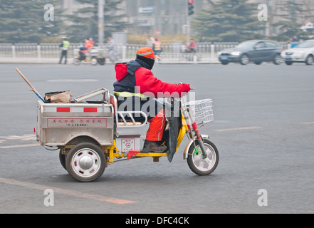 Nettoyeur de rue au volant d'un véhicule électrique à trois roues à Beijing, Chine Banque D'Images