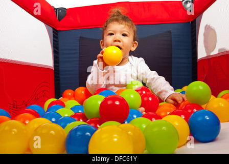 Bébé Garçon jouant avec boules colorées dans un parc pour enfants Banque D'Images