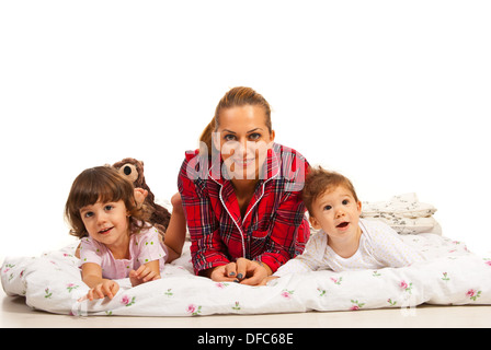 Heureuse mère au lit avec son petit kids against white background Banque D'Images