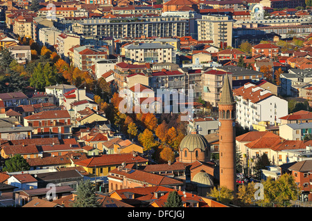 Les bâtiments urbains avec des toits rouges et de l'église éclairée par des derniers rayons du soleil couchant au soir à Alba, Italie (vue de dessus). Banque D'Images