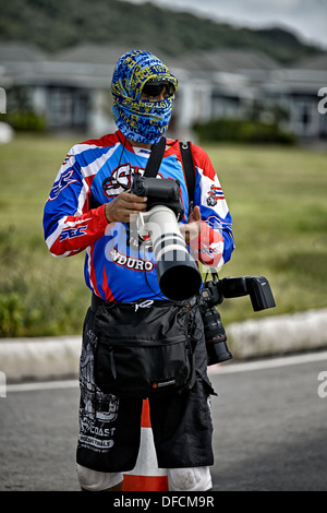 Attired coloré photographe professionnel prise de photos avec un assortiment de caméras et objectifs Canon. Banque D'Images