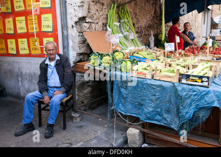 Un vieil homme à son kiosque de légumes dans le marché du Capo, Palerme, Italie Banque D'Images