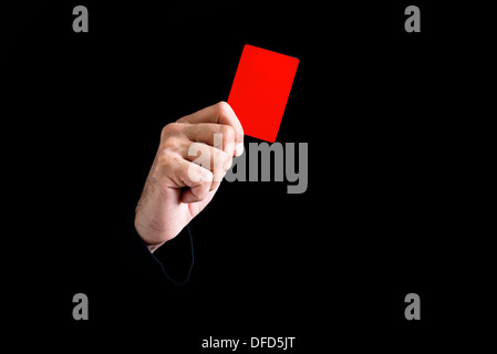 Arbitre de football donnant carte rouge sur fond noir. Banque D'Images