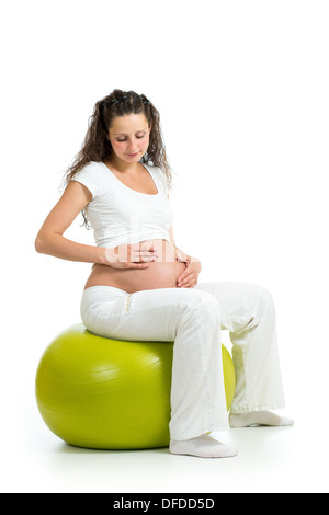 Pregnant woman sitting on fitness ball isolated Banque D'Images